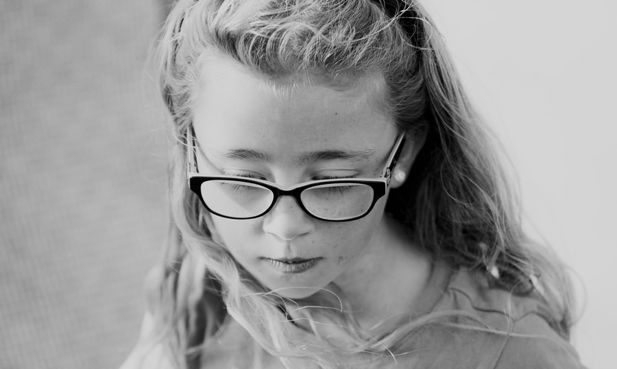Black and white photograph of a young girl in glasses