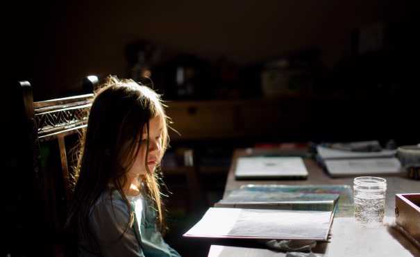 Young girl at kitchen table doing schoolwork
