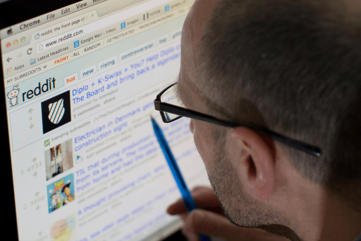 A man in wearing glasses looking at the Reddit homepage. Image credit: Alamy