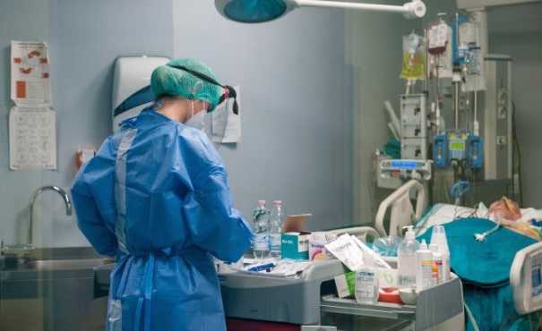 Nurse in PPE overlooking a coronavirus patient in the ICU