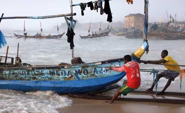 Fishermen pulling a boat in Ghana