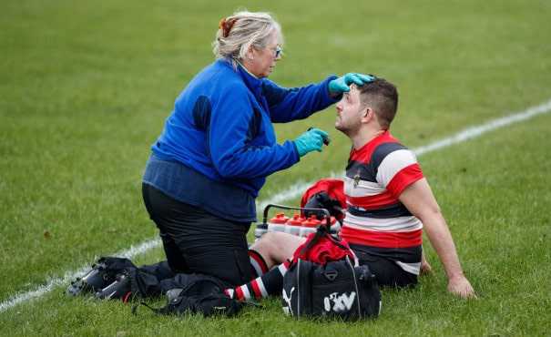 Rugby player being attended to by a medical practitioner