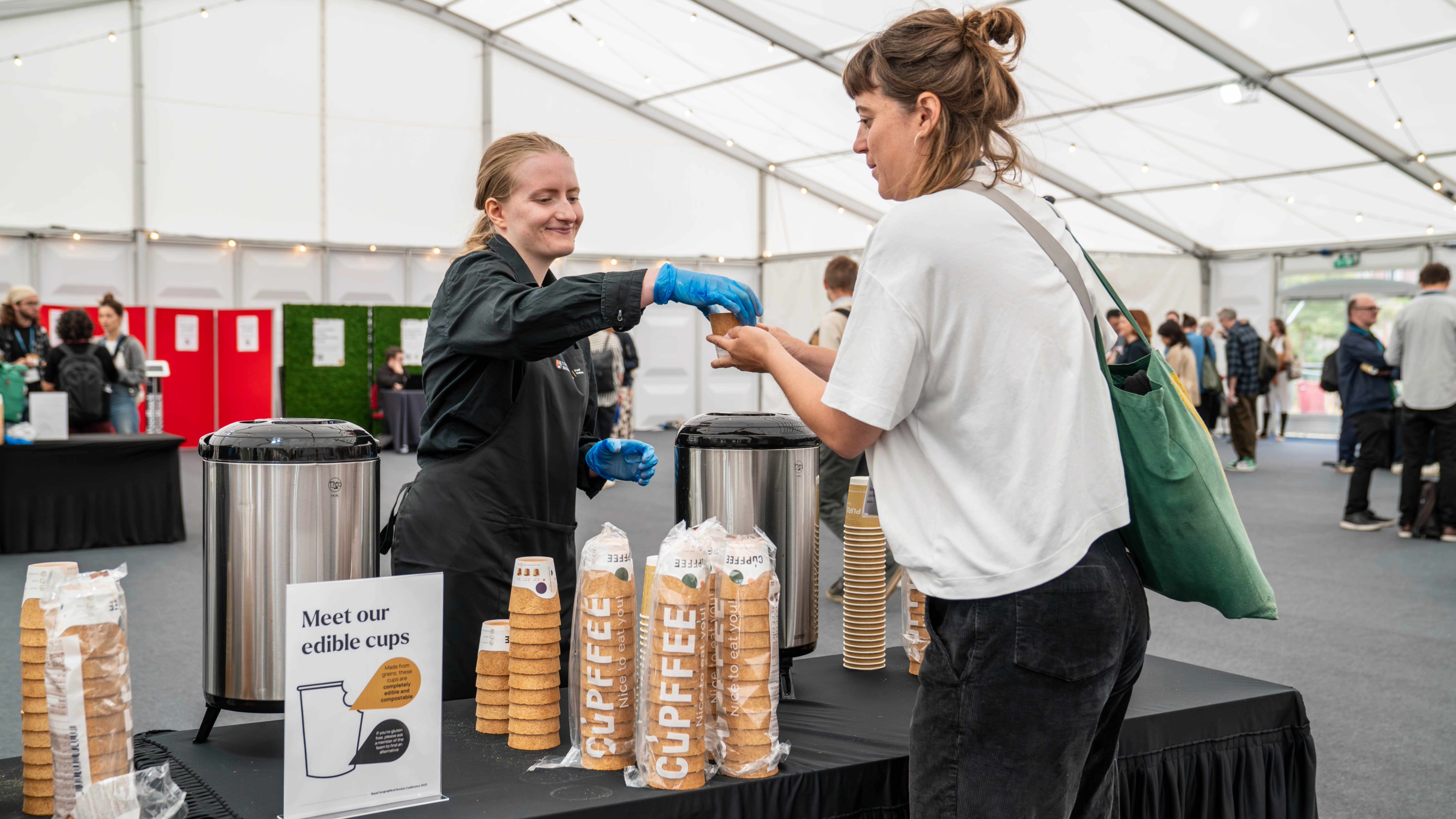 A staff member handing over an edible cup to a customer at an event