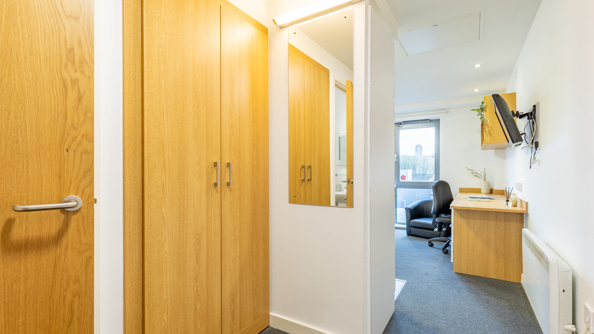Looking into the room with a cupboard on the left and a desk further down