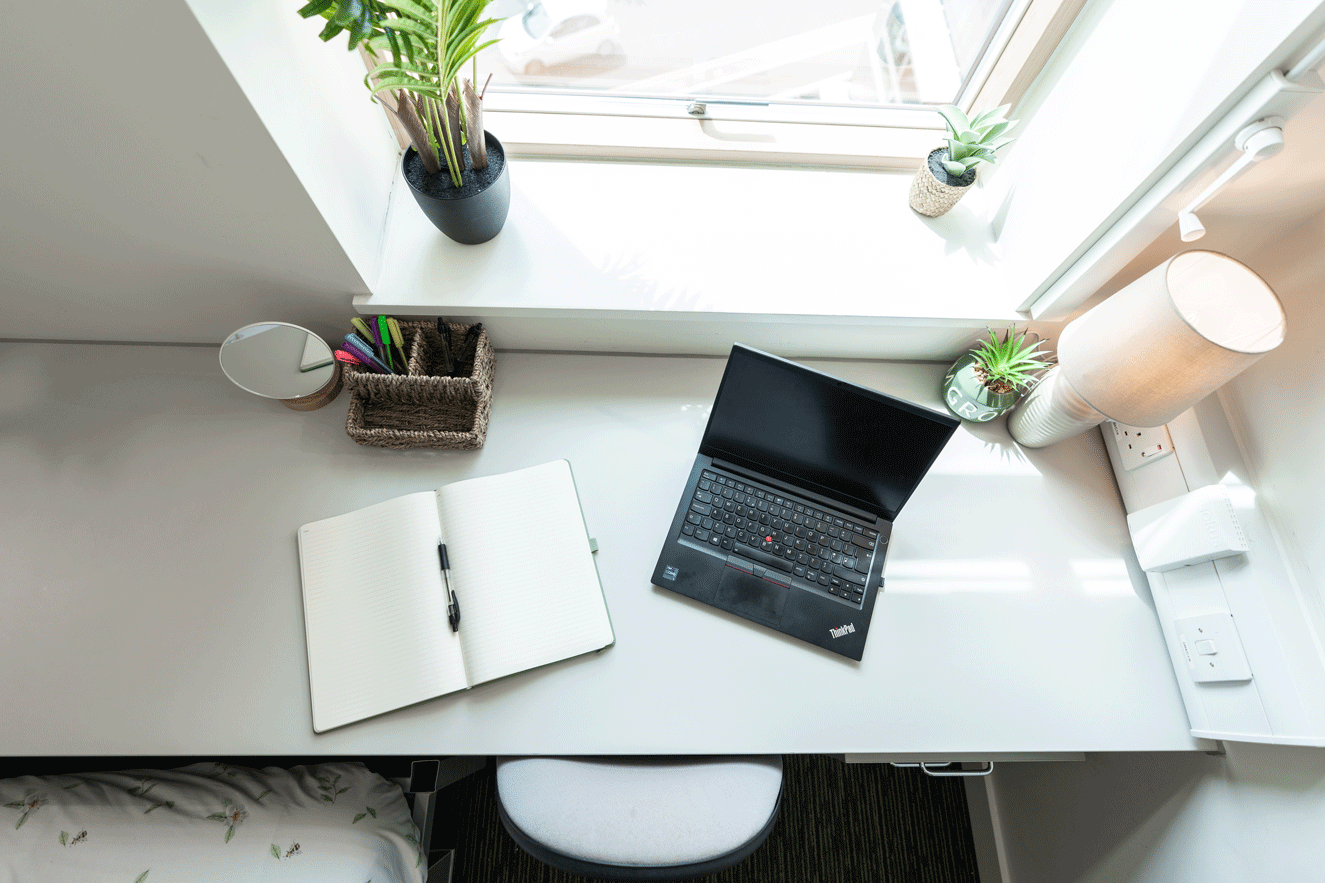 Desk with laptop and notepad on