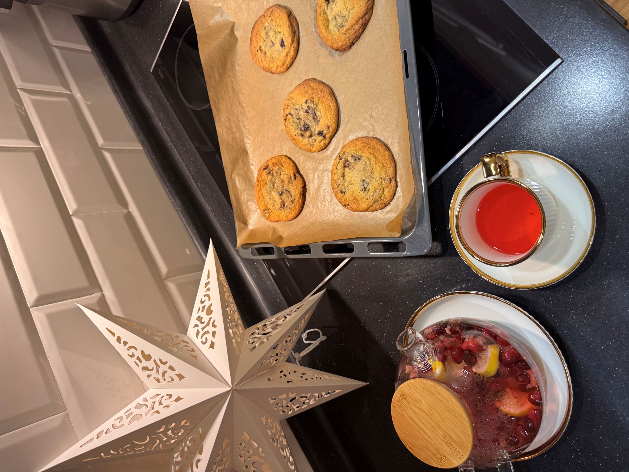 A baking tray of cookies and a cup of tea.