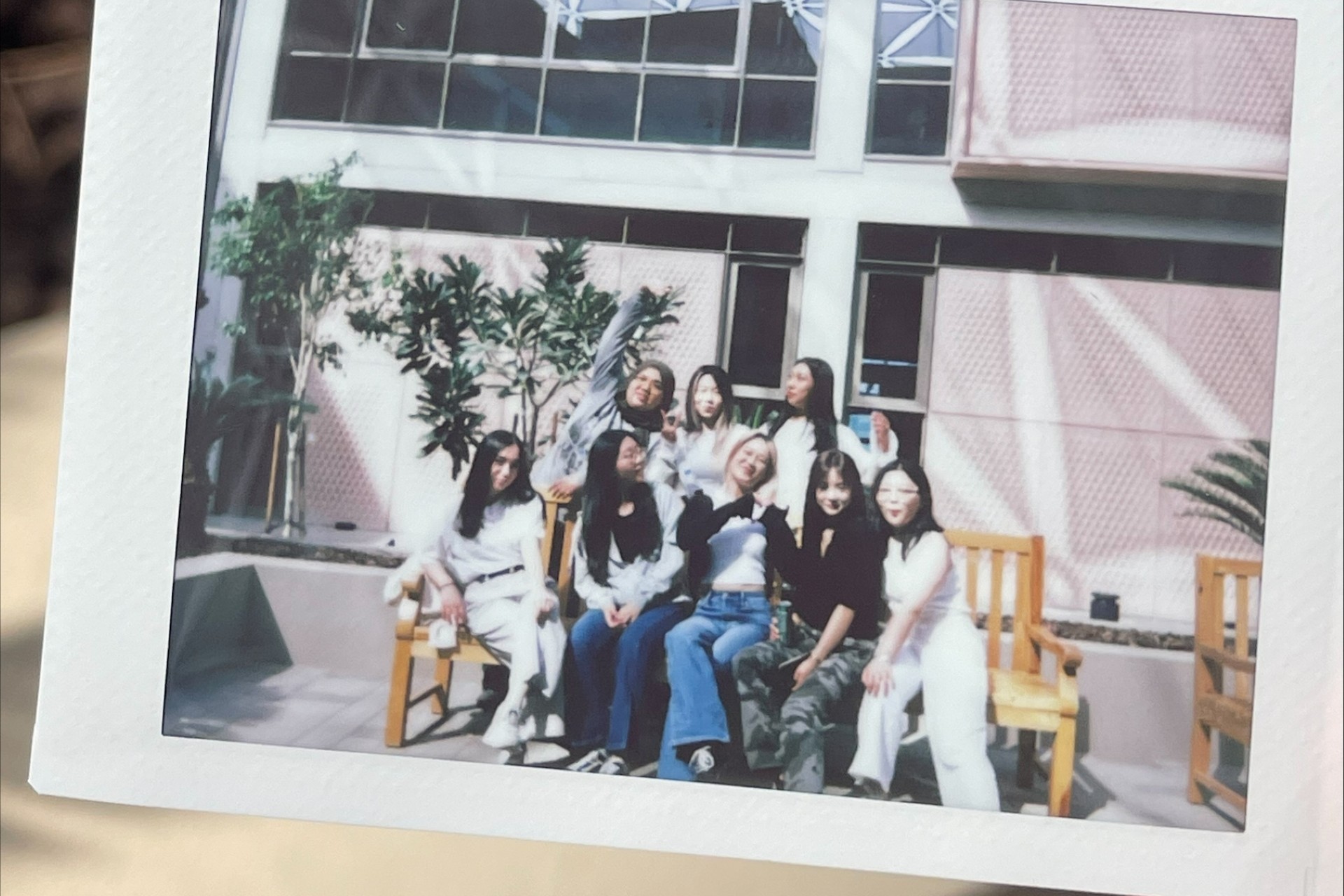 A Polaroid picture of a group of smiling students at the University of Birmingham Dubai.