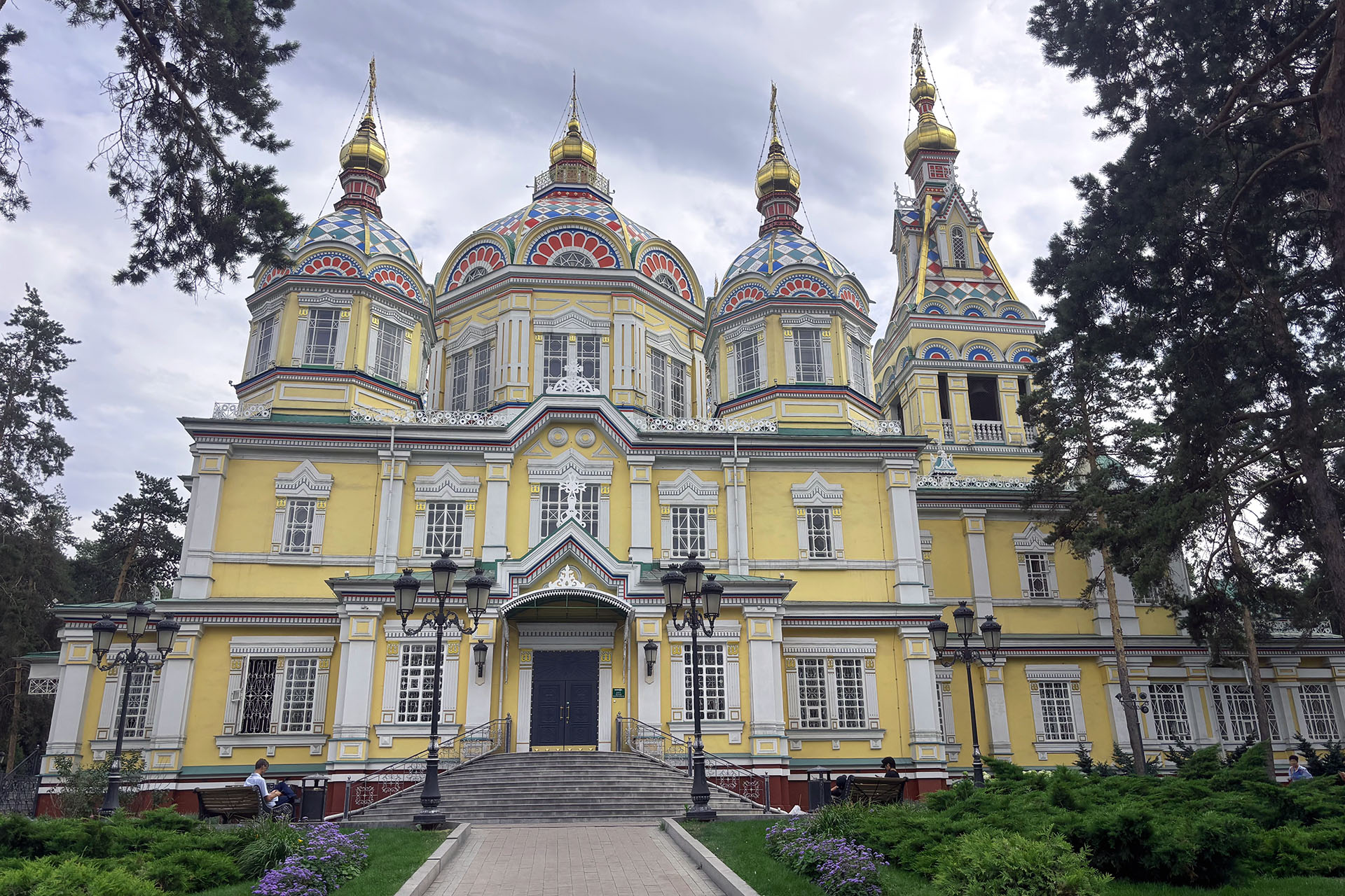 An ornate yellow building set in park grounds