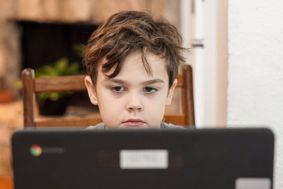 Boy stares at a laptop screen
