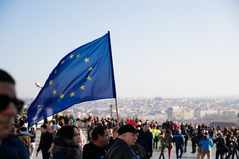 Crowds of people with walking with a European Flag