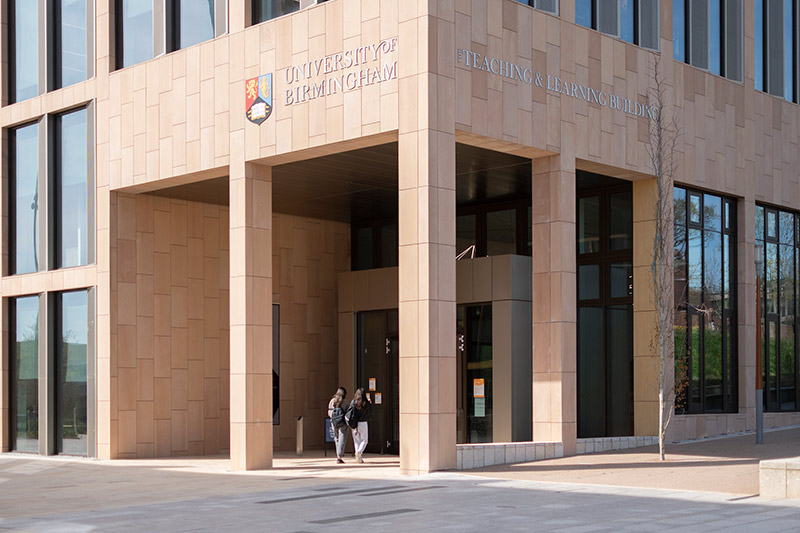 Two students walk into the Teaching and Learning Building