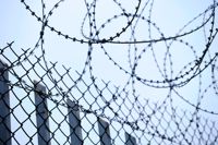 A chain link fence covered with razor wire