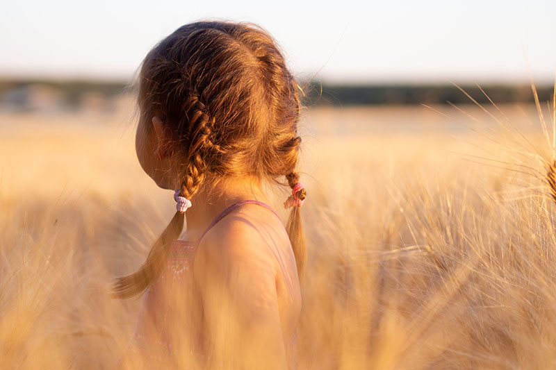 Young female child in a field looking into the distance