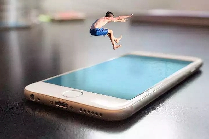Digitally composed image of a child jumping into a smartphone