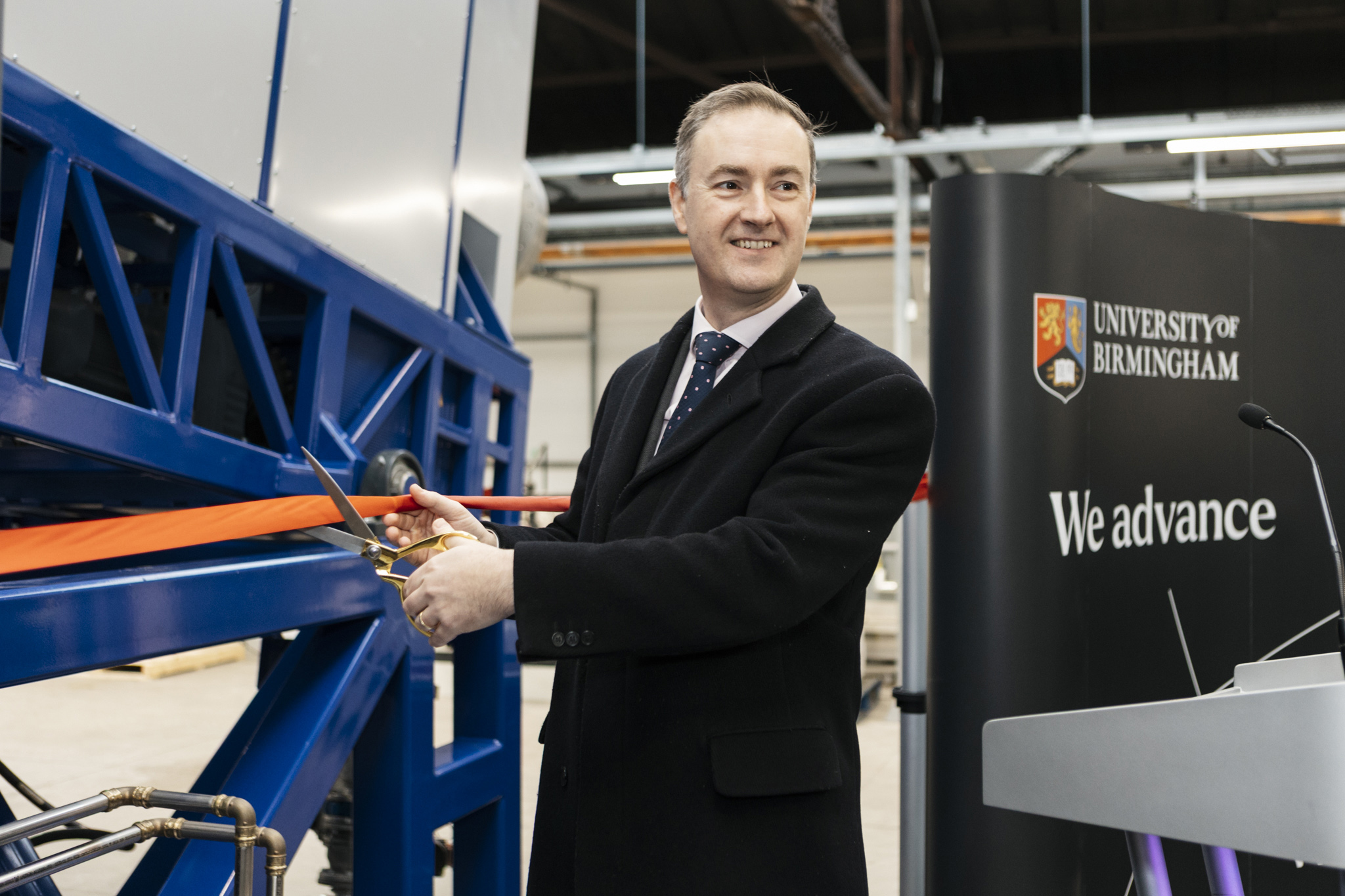 Chris McDonald MP cuts a ribbon at the opening of Birmingham’s rare earth magnet recycling facility.