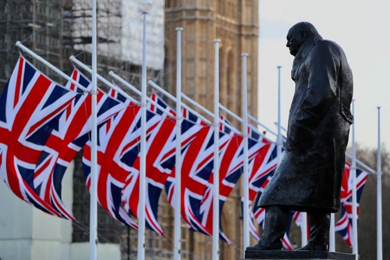 Statue of Winston Churchill with a row of union flags in the background