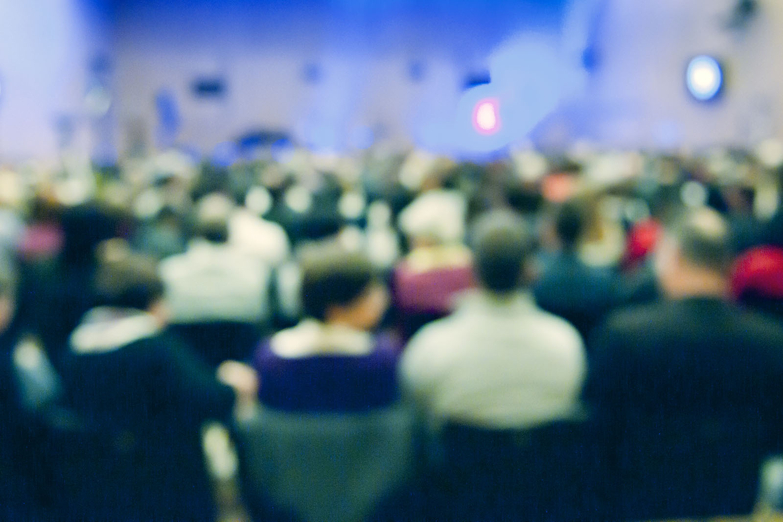 A blurred image of seated conference delegates