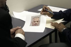 A police officer showing a witness an image of a suspect
