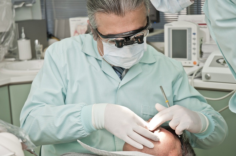Male dentist with mask and patient