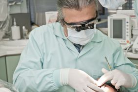 Male dentist with mask and patient