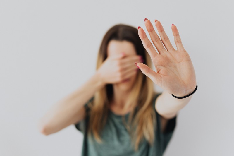 Woman covering her face with a hand