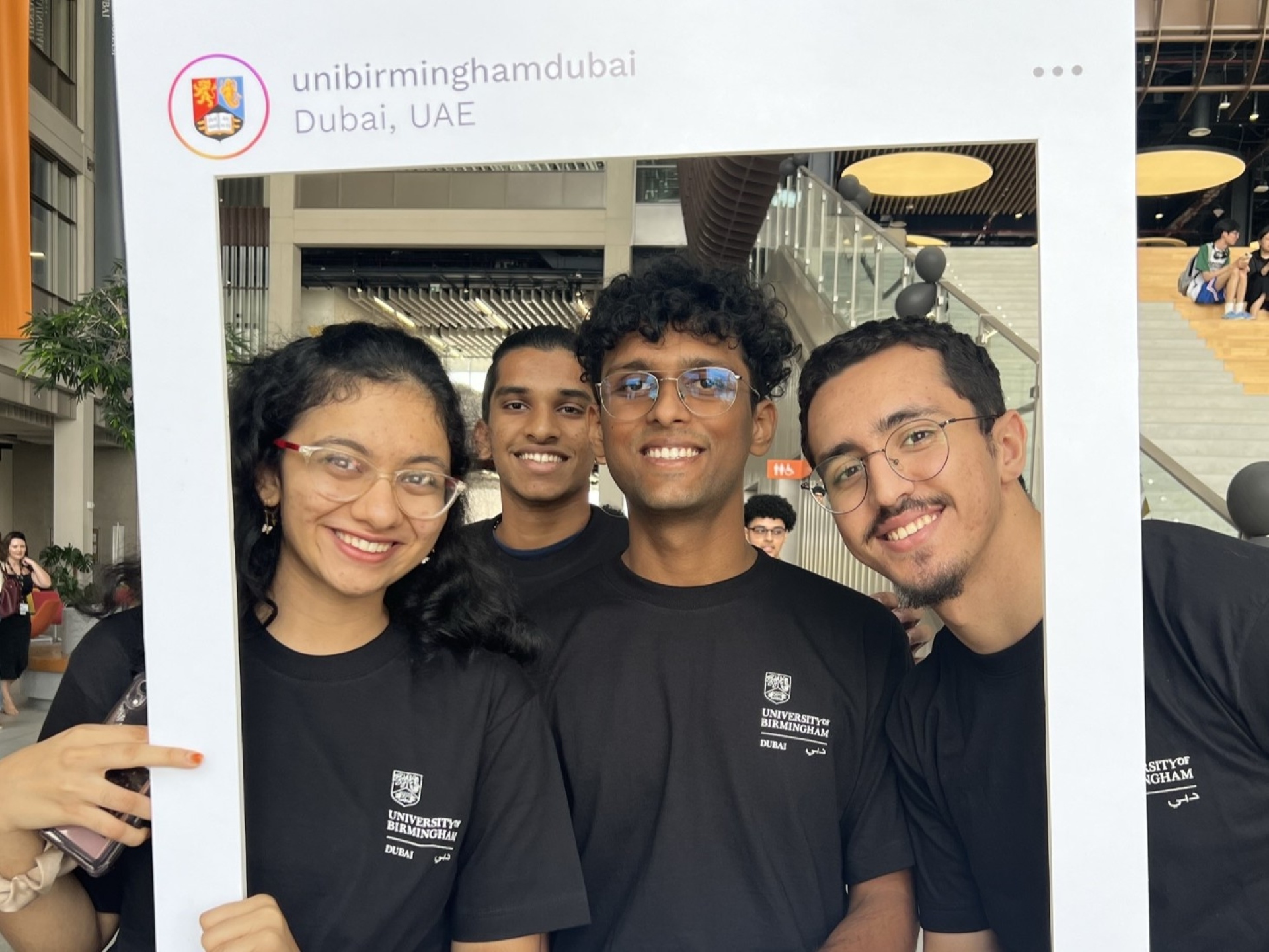 A group of students posing for a photo inside a mock Instagram frame prop.