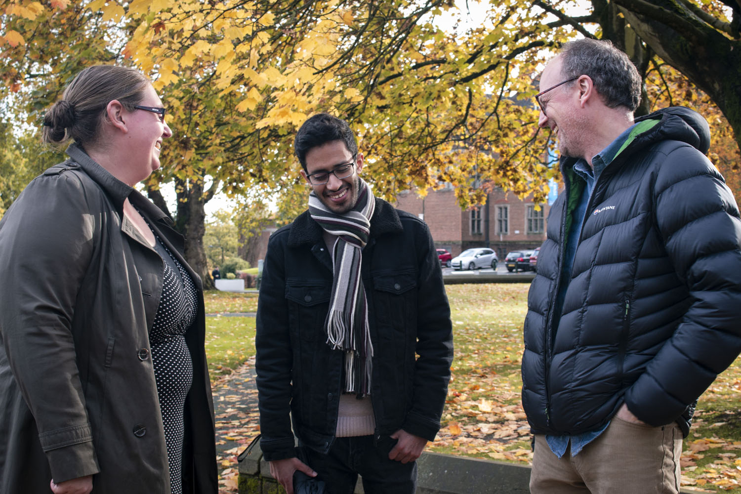 A man and his family stand in front of a tree
