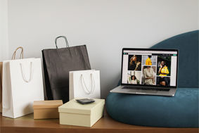Shopping bags next to a laptop displaying a fast fashion shopping website