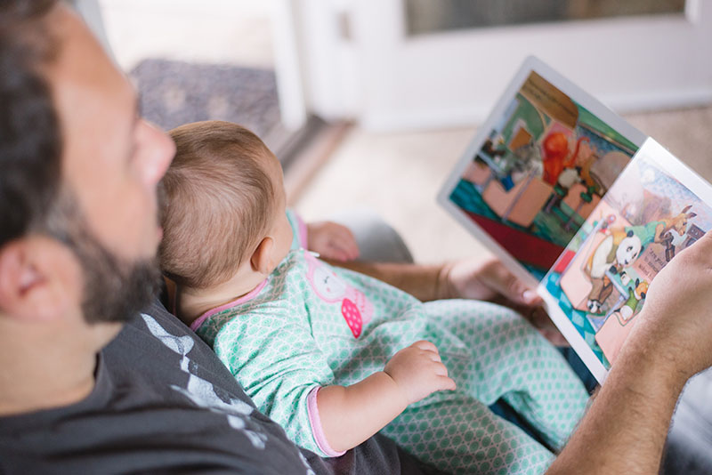 Father reading to his infant child