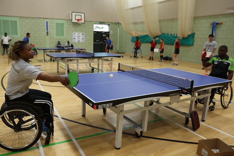 Two table tennis players in wheelchairs playing a game