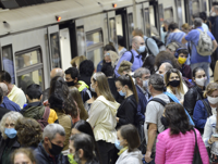 Subway train passengers wearing face masks crowding to get on and off the train