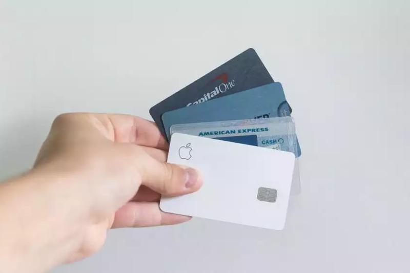 A hand holding a selection of credit cards
