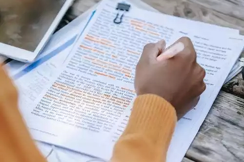 A student reading and highlighting a paper