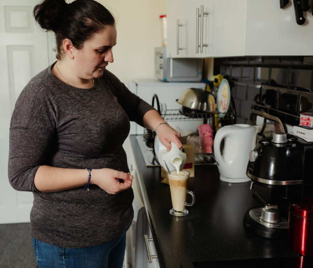 A woman making a cup of coffee