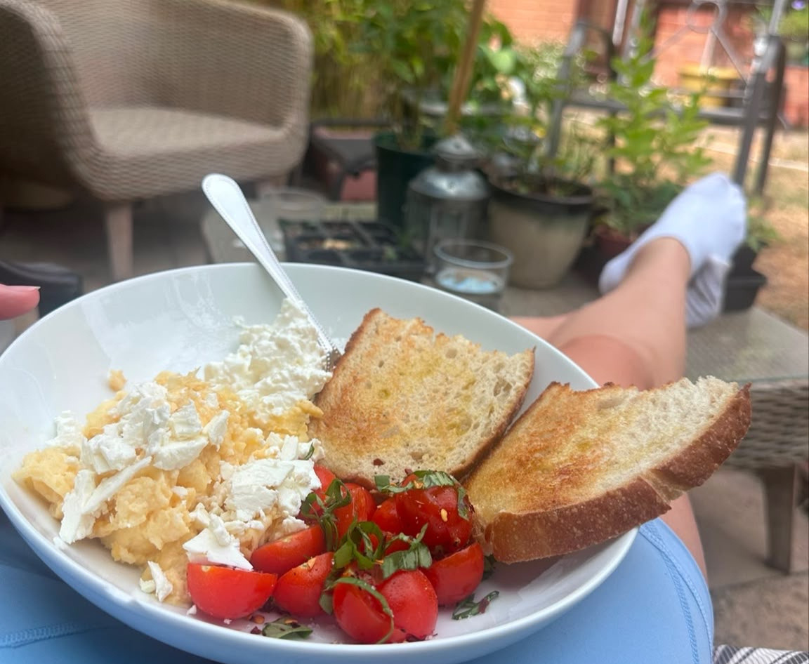 A bowl of bread, eggs and tomatoes in the garden on Harriet's lap