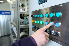 Operator pressing the 'start' button on Salinity's water treatment equipment 
