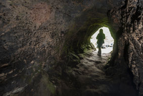 Child standing at entrance to cave