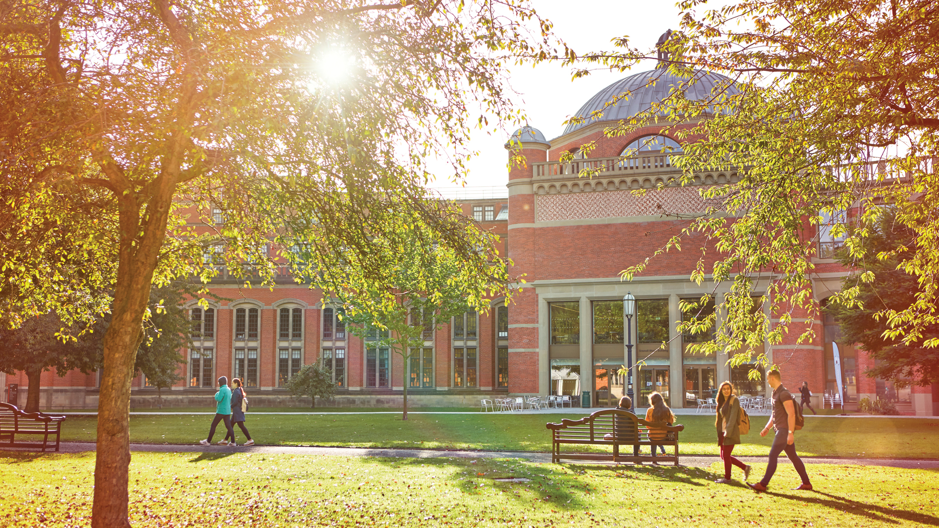 The Bramall Music Building in the sunshine with students walking past