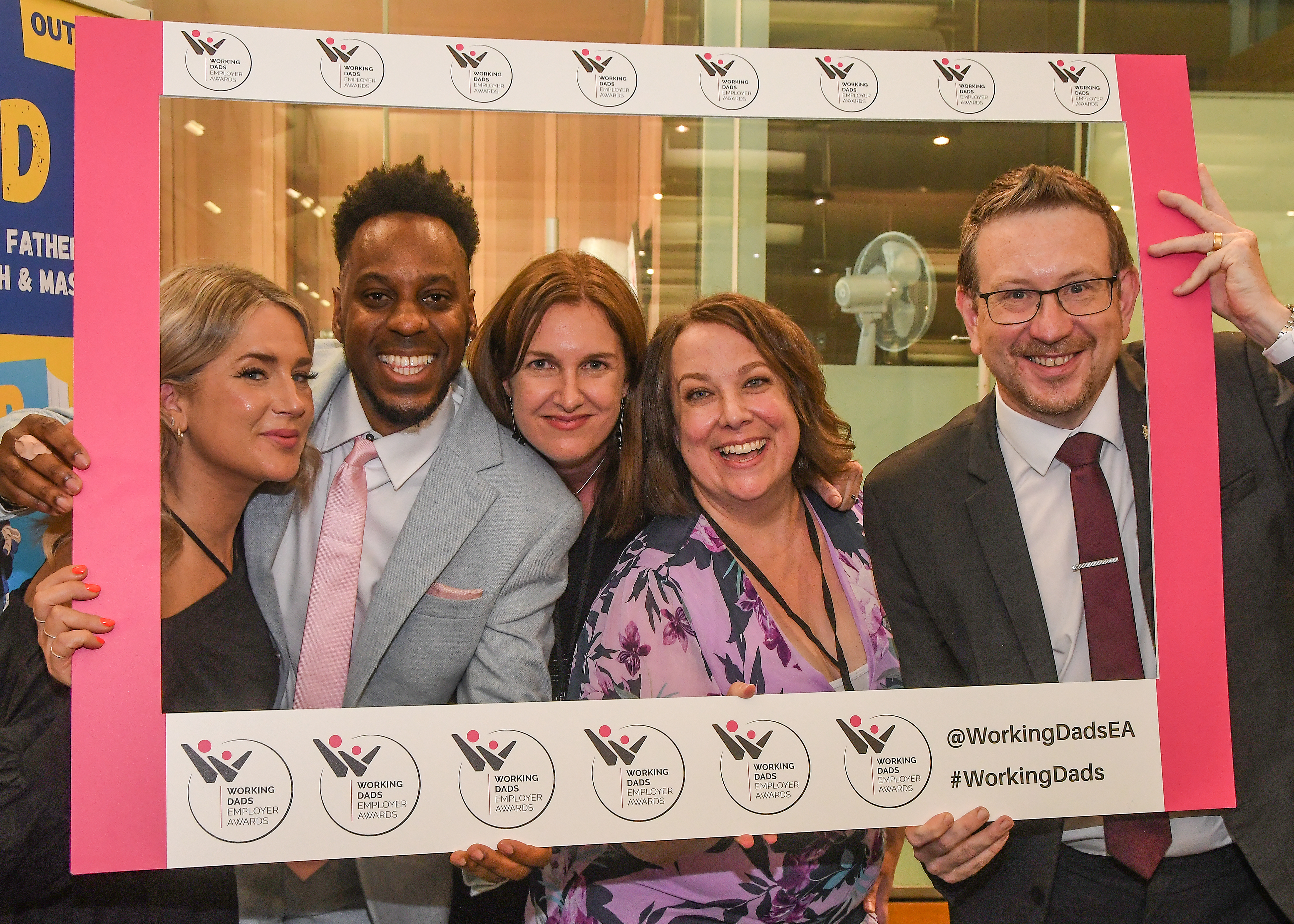  A group of people at the Working Dads Employers Awards holding a branded frame around themselves