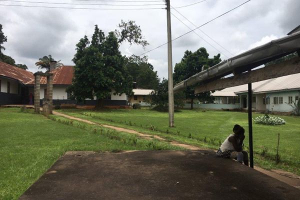A girl sitting outside St Benedicts in Ogoja, Nigeria