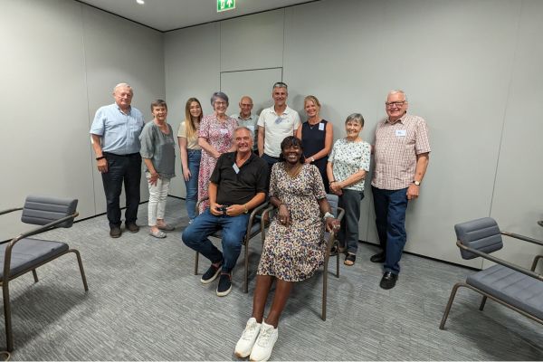 Eleven people (six women and five men) smiling at the camera in an event room.
