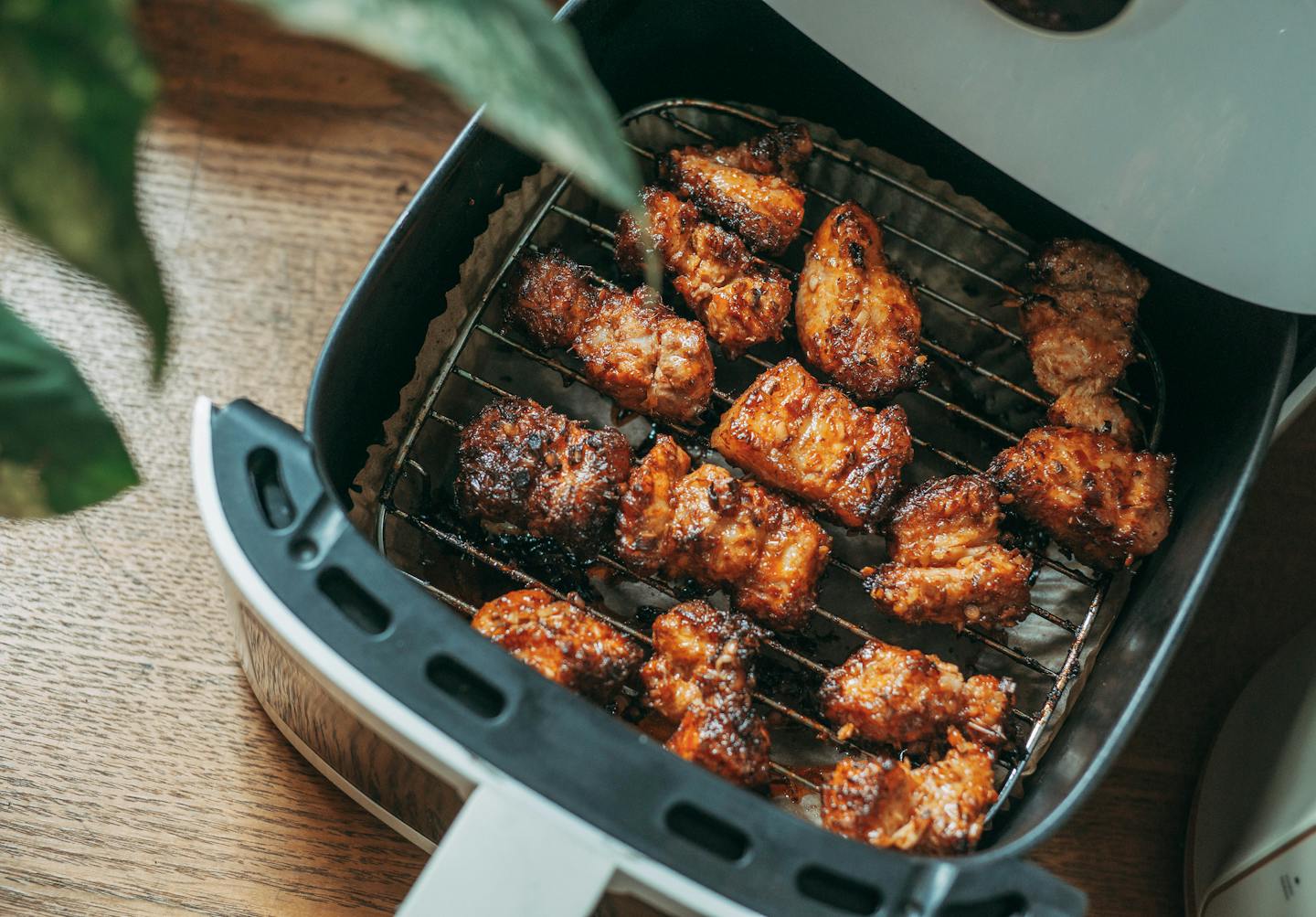 Top down view of air fryer with chicken pieces