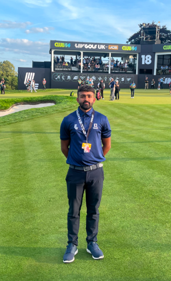 Aliakbar standing on a golf green looking at the camera