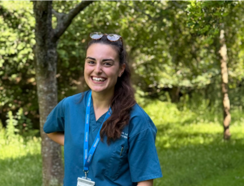 Annabel stood in woodland, looking at the camera smiling