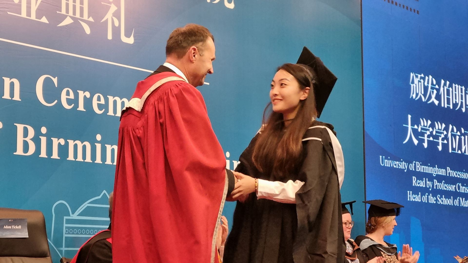 Vice-Chancellor presenting a graduating student with a degree