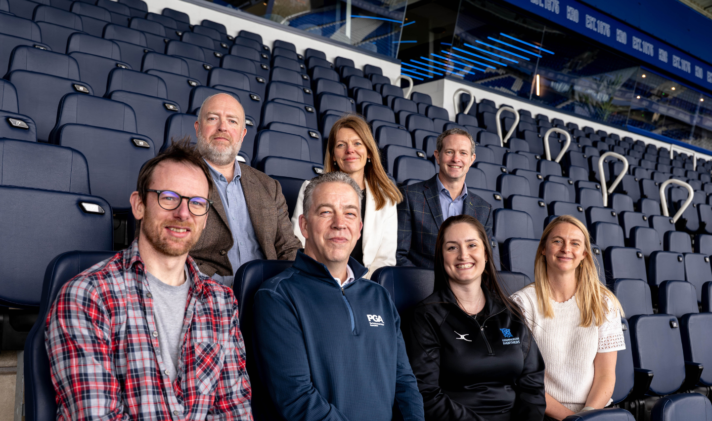 A group photo of the chairs and guest speakers sat in the BCFC stadium