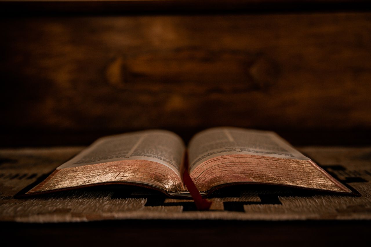 A Bible open on a wooden table.