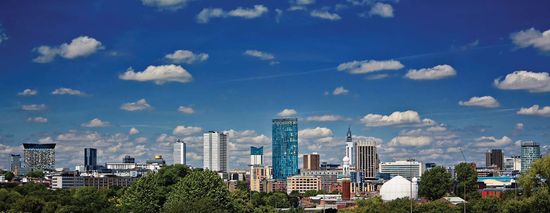 Birmingham skyline against a blue sky with white clouds