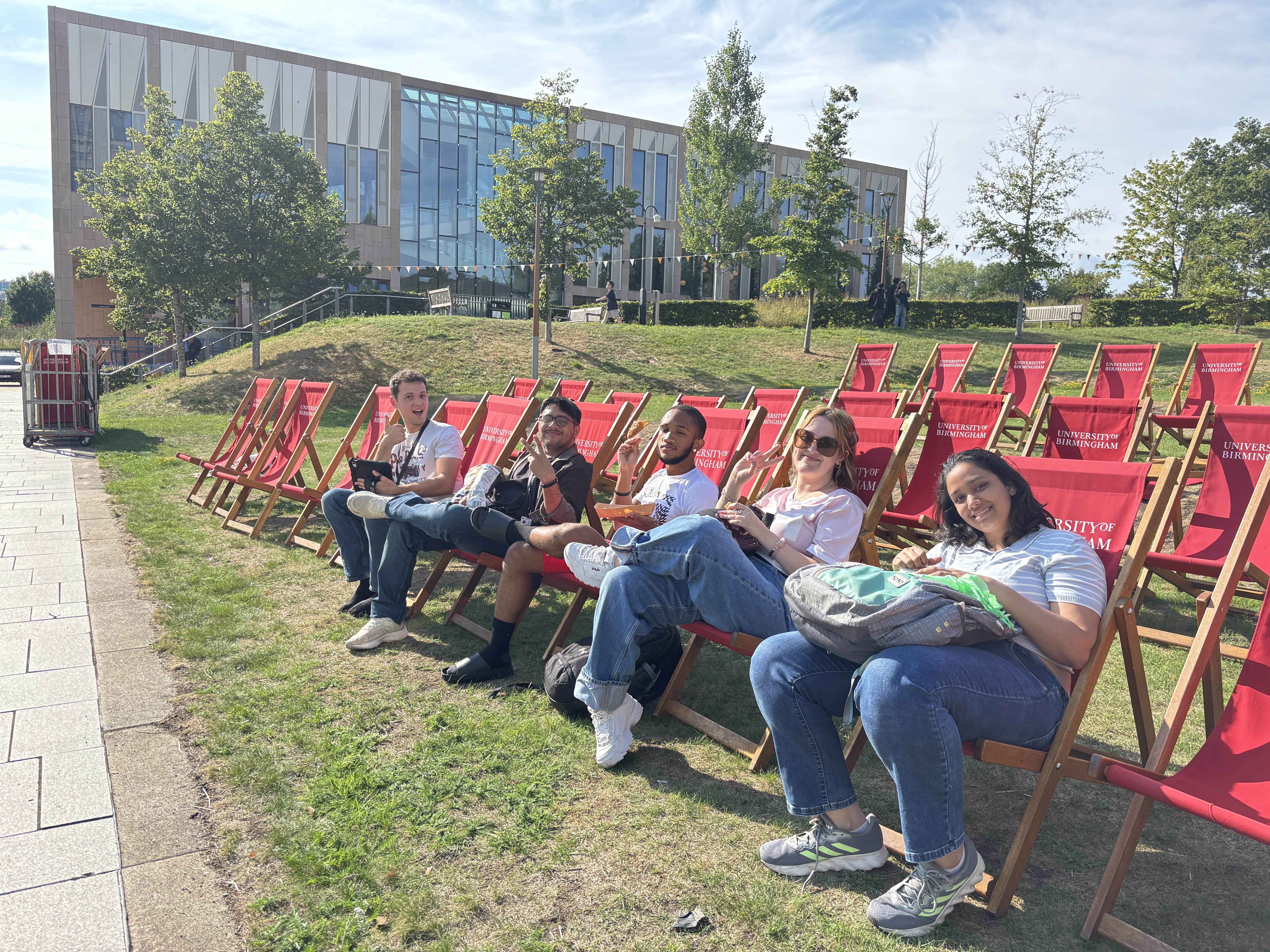 Summer school students sitting in lawn chair and posing for the camera on a UoB campus