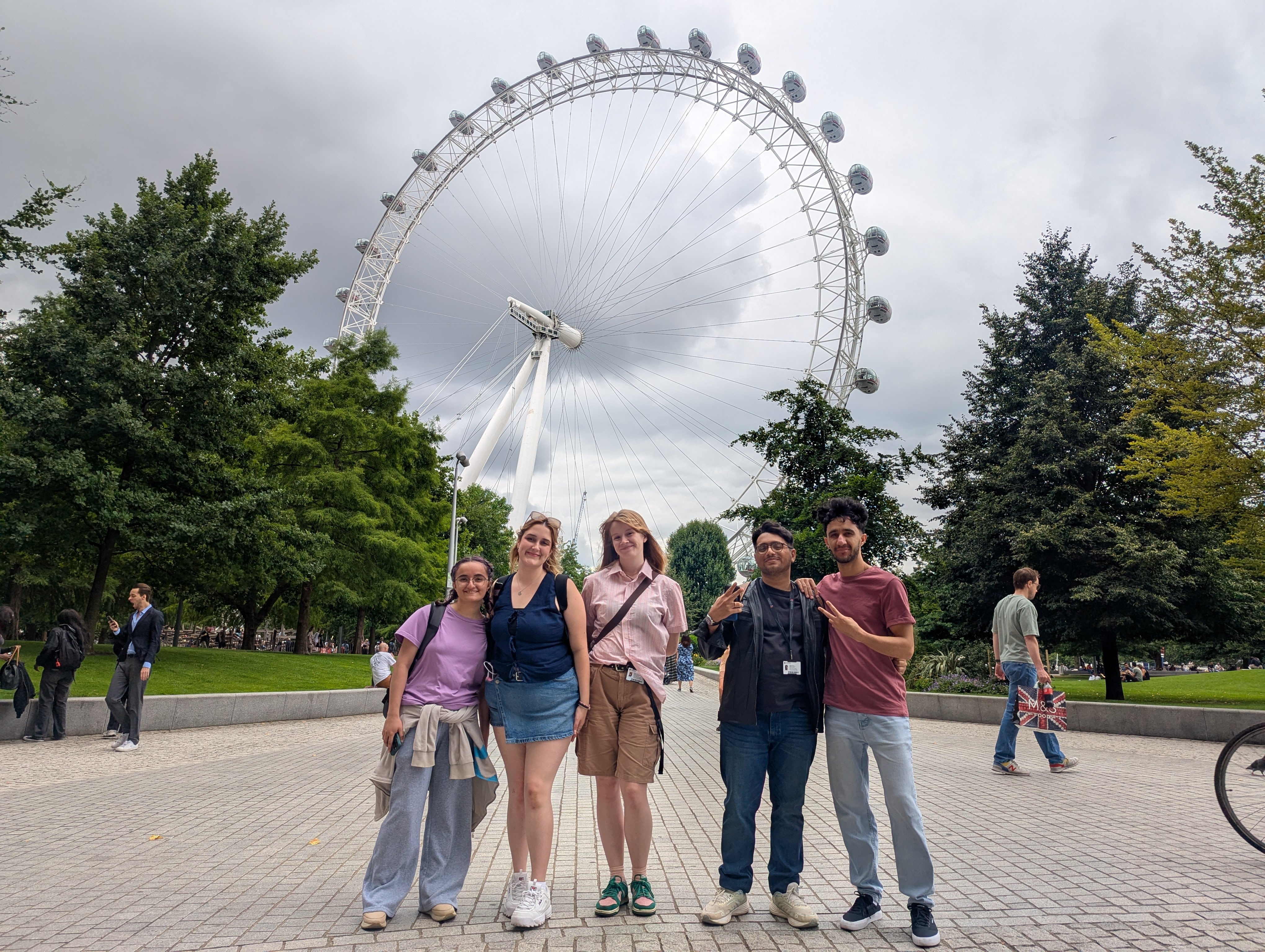 Summer school students posing with the London eye in the background